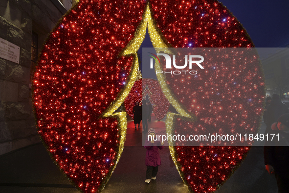 A girl looks at a glowing installation during the Christmas season in Kharkiv, Ukraine, on December 7, 2024. 