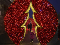 A girl looks at a glowing installation during the Christmas season in Kharkiv, Ukraine, on December 7, 2024. (