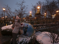 Two girls explore a big bauble during the Christmas season in Kharkiv, Ukraine, on December 7, 2024. (