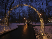 Arches decorated with string lights illuminate an alley in the park during the Christmas season in Kharkiv, Ukraine, on December 7, 2024. (