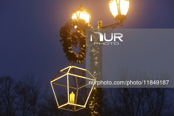 A lamppost decorated with a garland and a lantern is in the street during the Christmas season in Kharkiv, Ukraine, on December 7, 2024. 