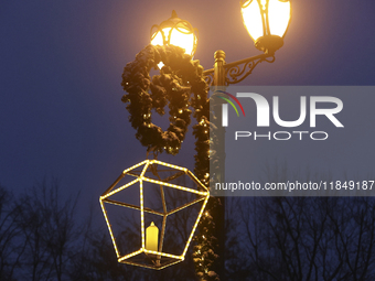 A lamppost decorated with a garland and a lantern is in the street during the Christmas season in Kharkiv, Ukraine, on December 7, 2024. (