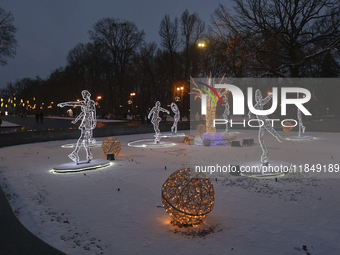 An installation featuring figures of ice skaters decorates the street during the Christmas season in Kharkiv, Ukraine, on December 7, 2024....