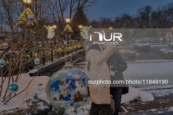 Women take a selfie in front of Christmas decorations in Kharkiv, Ukraine, on December 7, 2024. 