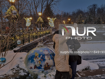 Women take a selfie in front of Christmas decorations in Kharkiv, Ukraine, on December 7, 2024. (