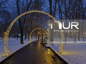 Arches decorated with string lights illuminate an alley in the park during the Christmas season in Kharkiv, Ukraine, on December 7, 2024. (