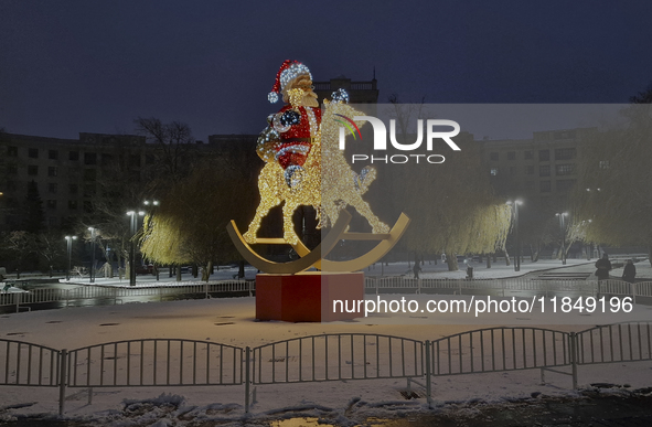 An installation featuring a large Santa Claus on a rocking horse decorates the street during the Christmas season in Kharkiv, Ukraine, on De...