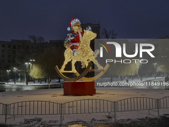 An installation featuring a large Santa Claus on a rocking horse decorates the street during the Christmas season in Kharkiv, Ukraine, on De...