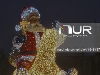 An installation featuring a large Santa Claus on a rocking horse decorates the street during the Christmas season in Kharkiv, Ukraine, on De...