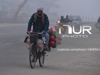 Vendors move through dense fog on a winter morning in Nagaon District, Assam, India, on December 8, 2024. (