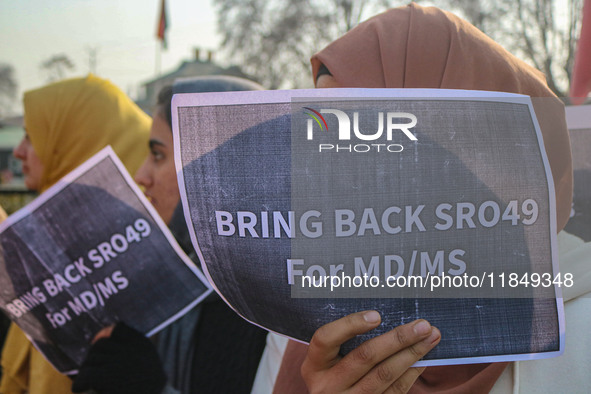 A student of Bachelor of Medicine and Bachelor of Surgery (MBBS) holds a placard during a protest against excessive reservation in competiti...