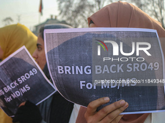 A student of Bachelor of Medicine and Bachelor of Surgery (MBBS) holds a placard during a protest against excessive reservation in competiti...