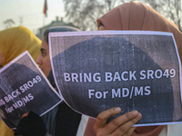 A student of Bachelor of Medicine and Bachelor of Surgery (MBBS) holds a placard during a protest against excessive reservation in competiti...