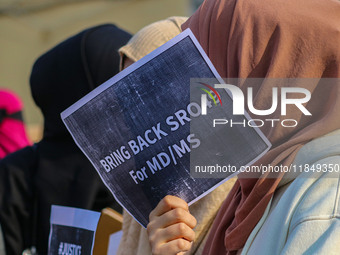 A student of Bachelor of Medicine and Bachelor of Surgery (MBBS) holds a placard during a protest against excessive reservation in competiti...