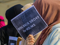 A student of Bachelor of Medicine and Bachelor of Surgery (MBBS) holds a placard during a protest against excessive reservation in competiti...