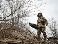 A serviceman of a self-propelled howitzer crew from Ukraine's 118th Separate Mechanized Brigade uses an anti-drone rifle while on a mission...