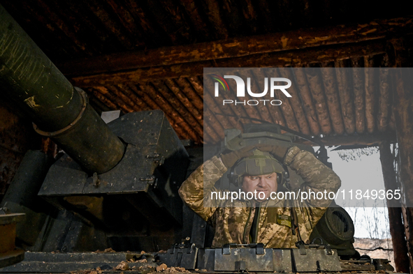 An artilleryman stands in the hatch of a self-propelled howitzer of Ukraine's 118th Separate Mechanized Brigade while on a mission in the Za...