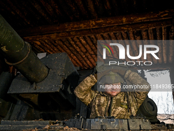 An artilleryman stands in the hatch of a self-propelled howitzer of Ukraine's 118th Separate Mechanized Brigade while on a mission in the Za...