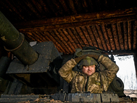 An artilleryman stands in the hatch of a self-propelled howitzer of Ukraine's 118th Separate Mechanized Brigade while on a mission in the Za...