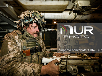 An artilleryman of Ukraine's 118th Separate Mechanized Brigade is inside a self-propelled howitzer while on a mission in the Zaporizhzhia di...