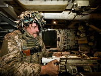 An artilleryman of Ukraine's 118th Separate Mechanized Brigade is inside a self-propelled howitzer while on a mission in the Zaporizhzhia di...