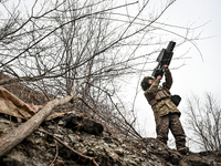 A serviceman of a self-propelled howitzer crew from Ukraine's 118th Separate Mechanized Brigade uses an anti-drone rifle while on a mission...