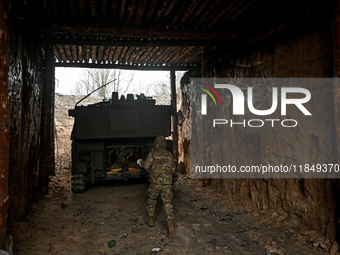 An artilleryman of Ukraine's 118th Separate Mechanized Brigade stands by a self-propelled howitzer while on a mission in the Zaporizhzhia di...