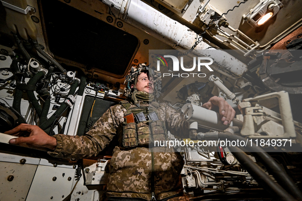 An artilleryman of Ukraine's 118th Separate Mechanized Brigade is inside a self-propelled howitzer while on a mission in the Zaporizhzhia di...