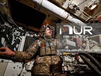 An artilleryman of Ukraine's 118th Separate Mechanized Brigade is inside a self-propelled howitzer while on a mission in the Zaporizhzhia di...