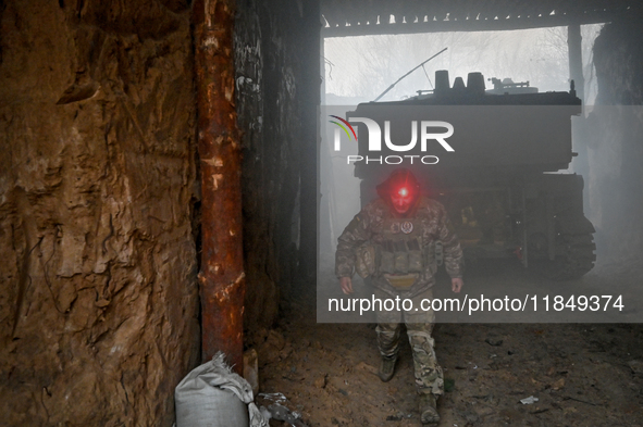 An artilleryman of Ukraine's 118th Separate Mechanized Brigade stands by a self-propelled howitzer while on a mission in the Zaporizhzhia di...