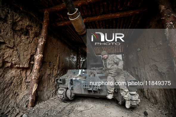 An artilleryman of Ukraine's 118th Separate Mechanized Brigade stands by a self-propelled howitzer while on a mission in the Zaporizhzhia di...