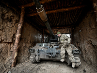 An artilleryman of Ukraine's 118th Separate Mechanized Brigade stands by a self-propelled howitzer while on a mission in the Zaporizhzhia di...