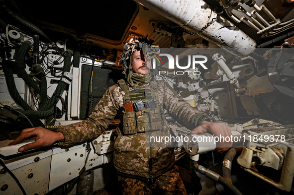 An artilleryman of Ukraine's 118th Separate Mechanized Brigade is inside a self-propelled howitzer while on a mission in the Zaporizhzhia di...