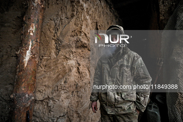 A serviceman of a self-propelled howitzer crew of Ukraine's 118th Separate Mechanized Brigade smokes a cigarette at the positions in the Zap...