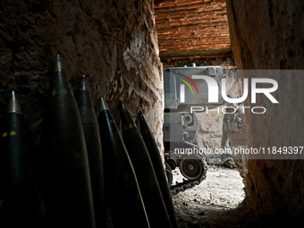 An artilleryman of a self-propelled howitzer crew from Ukraine's 118th Separate Mechanized Brigade is seen from an ammunition storage space...