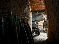 An artilleryman of a self-propelled howitzer crew from Ukraine's 118th Separate Mechanized Brigade is seen from an ammunition storage space...