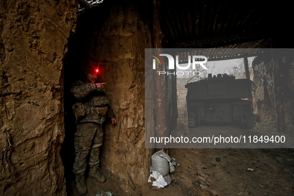 An artilleryman of Ukraine's 118th Separate Mechanized Brigade stands by a self-propelled howitzer while on a mission in the Zaporizhzhia di...