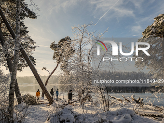 People enjoy a cold winter day at Lakes Osterseen in Iffeldorf, Bavaria, Germany, on January 14, 2024. Osterseen is a group of lakes in Bava...