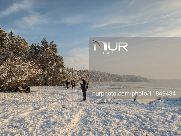 People enjoy a cold winter day at Lakes Osterseen in Iffeldorf, Bavaria, Germany, on January 14, 2024. Osterseen is a group of lakes in Bava...