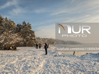 People enjoy a cold winter day at Lakes Osterseen in Iffeldorf, Bavaria, Germany, on January 14, 2024. Osterseen is a group of lakes in Bava...