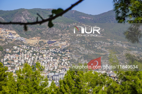 A view of dense housing development with mountains in the background and a Turkish flag in the wind is seen in Alanya, Turkey, on November 2...