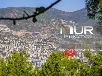 A view of dense housing development with mountains in the background and a Turkish flag in the wind is seen in Alanya, Turkey, on November 2...