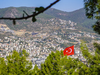 A view of dense housing development with mountains in the background and a Turkish flag in the wind is seen in Alanya, Turkey, on November 2...