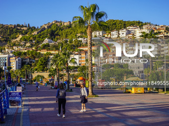 Women walk along a seaside promenade in Alanya, Turkey, on November 3, 2024 (