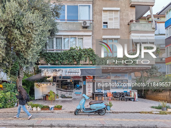 A blue scooter moped stands in front of a local barber shop in Alanya, Turkey, on November 7, 2024. (