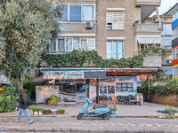 A blue scooter moped stands in front of a local barber shop in Alanya, Turkey, on November 7, 2024. (