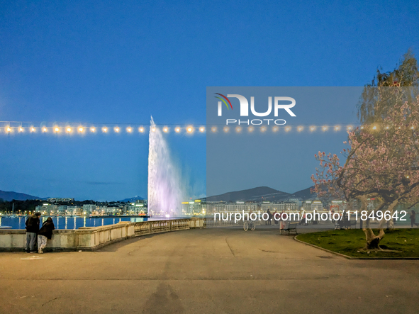 People enjoy an early evening on Lake Geneva in Geneva, Switzerland, on April 9, 2023, watching the Jet d'eau, a fountain in Lake Geneva wit...