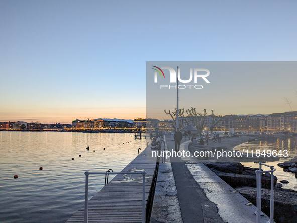 People take an early evening walk at Lake Geneva in Geneva, Switzerland, on April 9, 2023. 