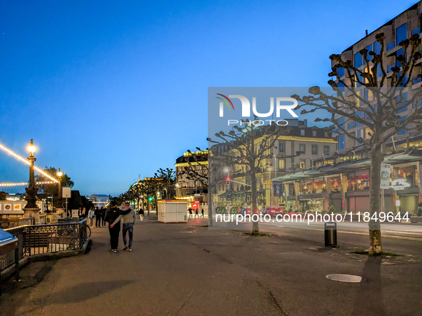 People take an early evening walk at Lake Geneva in Geneva, Switzerland, on April 9, 2023. 