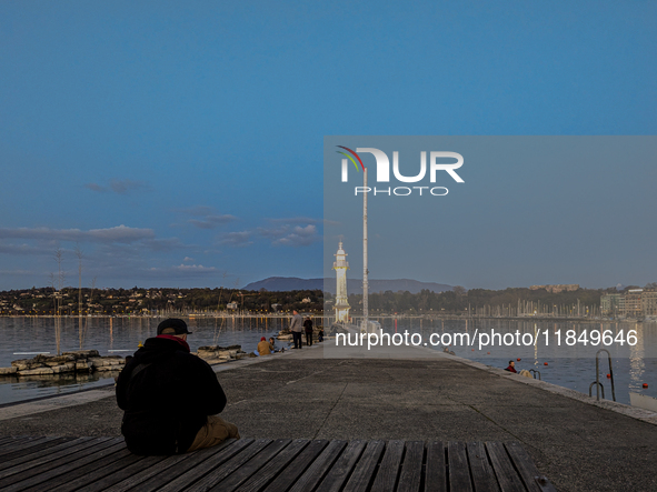 People enjoy an early evening on Lake Geneva in Geneva, Switzerland, on April 9, 2023, watching the Phare des Paquis, a lighthouse on Lake G...